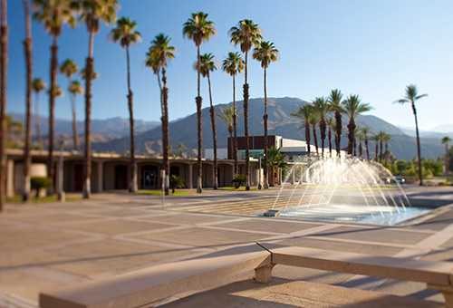 Photo of a building at the College of the Desert with palm trees in front and a water fountain feature.