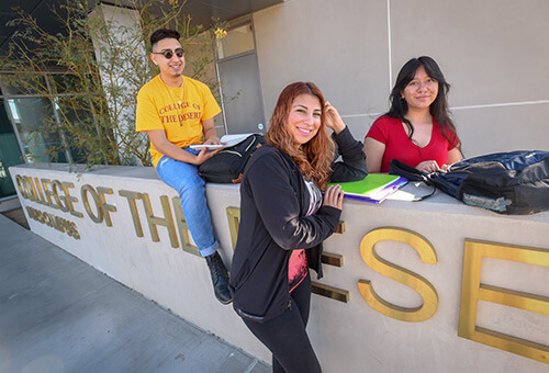Photo of 3 students next to the College of the Desert Sign